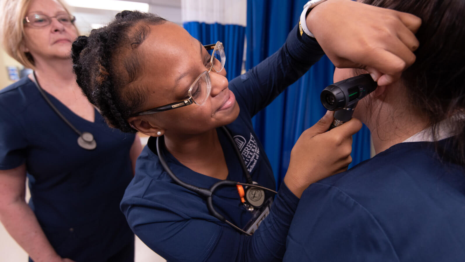 nursing students examining a patient